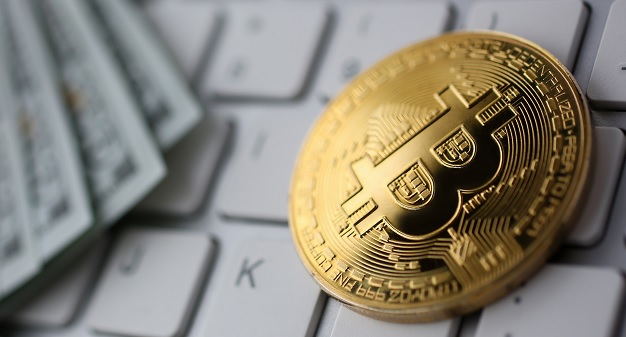 Bitcoin and  bank notes on a keyboard